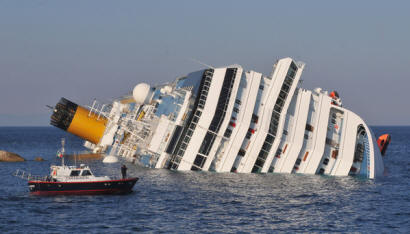 La nave Costa Concordia inclinata ed adagiata su un fianco.